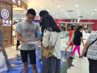 （图为小组成员正在进行问卷调查。）